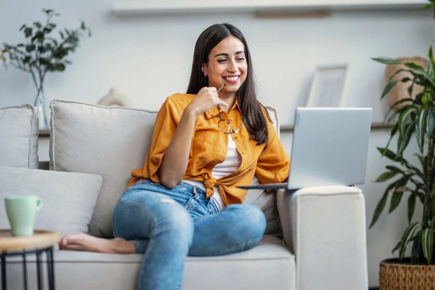 Frau laptop sofa homeoffice laecheln
